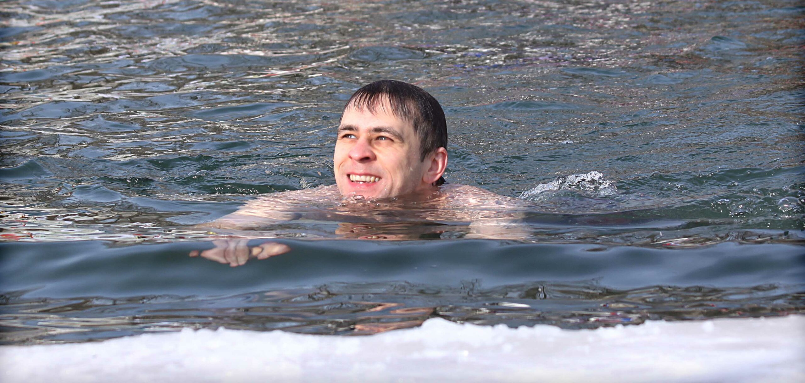 man swimming in cold water during Polar Bear Plunge