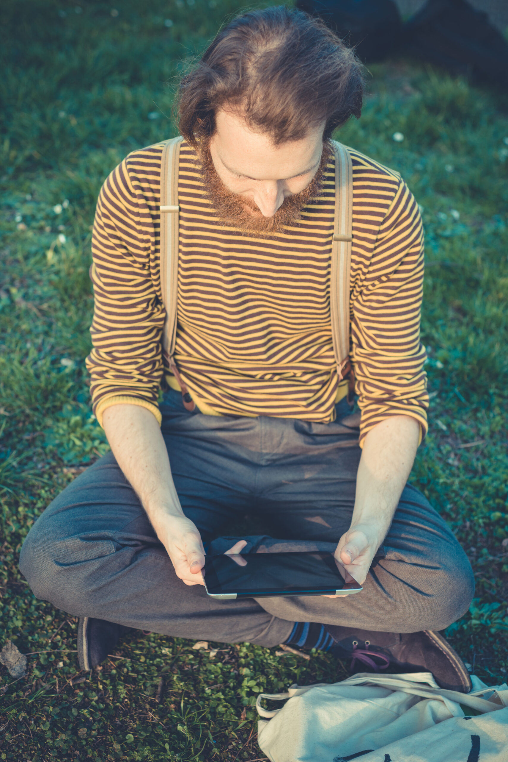 young bearded stylish handsome hipster man using tablet Whidbey Telecom Outdoor WiFi